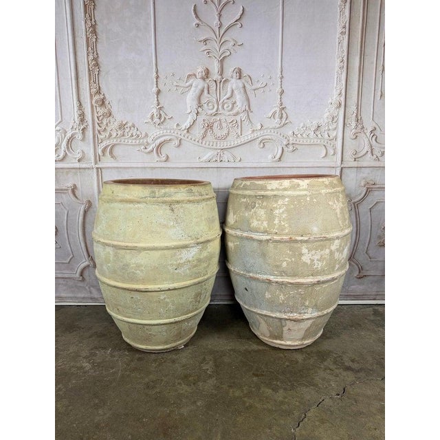 A striking and highly decorative pair of monumental barrel-form olive jar planters in the classic Mediterranean tradition,...