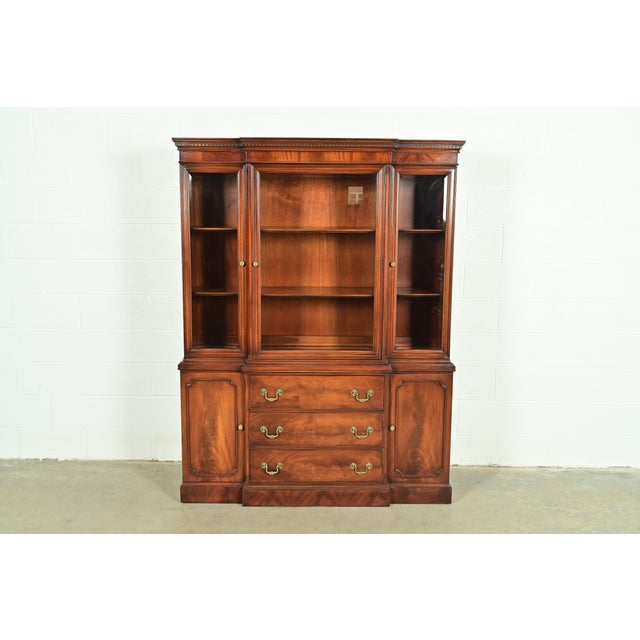 An exceptional Georgian or Chippendale style breakfront bookcase or dining cabinet By White Furniture USA, Circa 1960s...