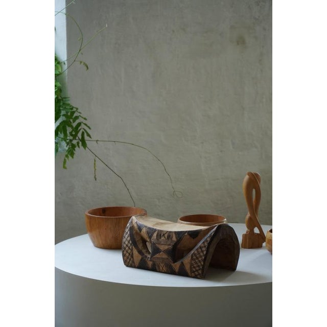 A highly decorative hand-carved African stool dating from the mid-20th century. Carved from a single piece of wood, the...
