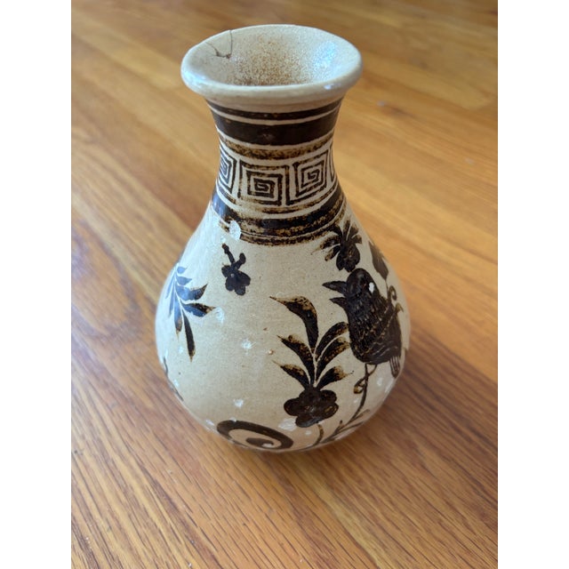 A rustic Chinese Cizhou kiln ceramic vase featuring classic hand-painted iron-black slip decoration over a creamy glaze....