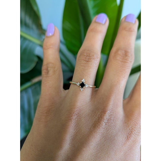 /A natural black diamond anchors this solid 14K yellow gold ring in a bold asscher cut, surrounded by twelve white earth-...