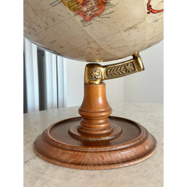 1980s Replogle globe with a lovely antiqued sepia brown tone. Spins on a decorated brass support atop a turned-wood base....