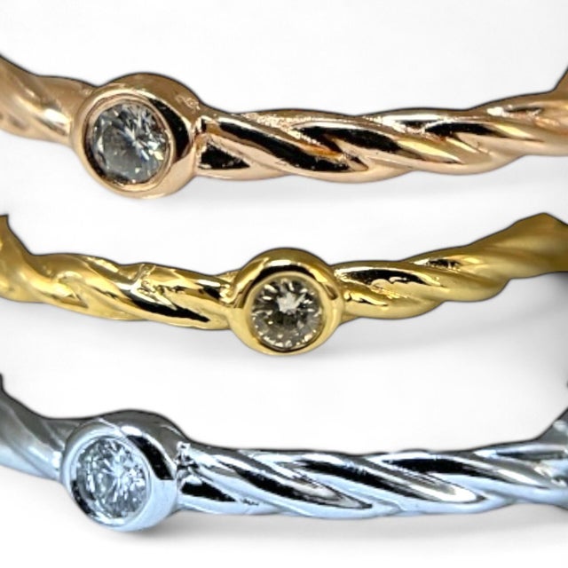 Crafted in luxurious 14K yellow gold, this elegant ring features a unique twisted rope design, enhanced by brilliant...