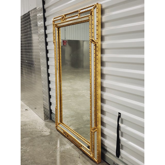 Gorgeous Italian Hollywood Regency style mirror with mirrored faux bamboo carved giltwood frame. The rectangular form...