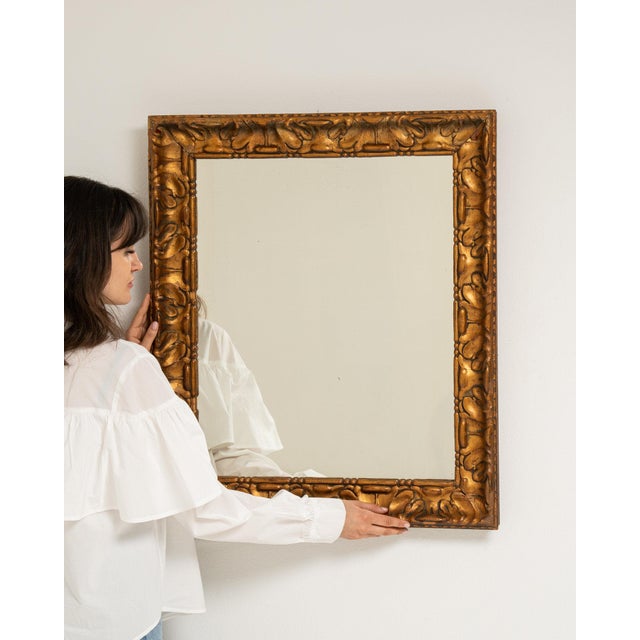This piece presents as a mirror, distinguished by gold ornate textured frame, rectangular. Dating to 1900s and originating...