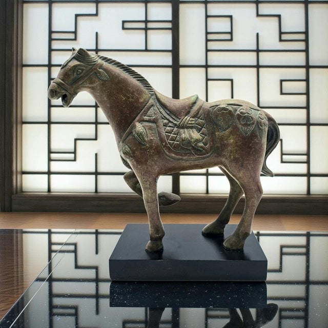 A late twentieth-century Chinese Tang Dynasty-style decorative horse sculpture, circa 1970–1999, cast in patinated metal...