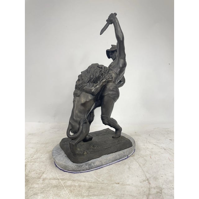 A beautiful antique metal sculpture with a marble base depicting a fight between a lion and a warrior. A great decorative...