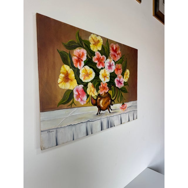 A vibrant oil on canvas still life painting signed “J. Francis,” featuring a lush and colorful arrangement of hibiscus...