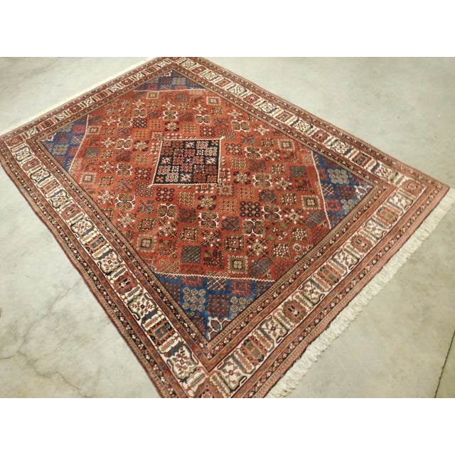 Diamond pattern with geometric medallion on a red/rust background with reciprocating spandrels. Floral decorated ivory...