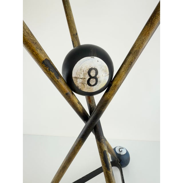 A playful vintage accent table inspired by the game of billiards, featuring an open tripod frame accented with oversized...