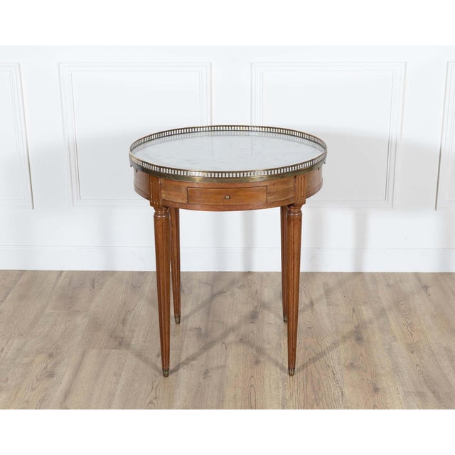 An elegant Louis XVI-style bouillotte table from France, dating to the late 19th century, finely crafted in mahogany with...