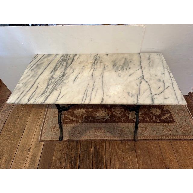 Classic rectangular bistro table having white and grey marble top and beautiful black iron base. GG