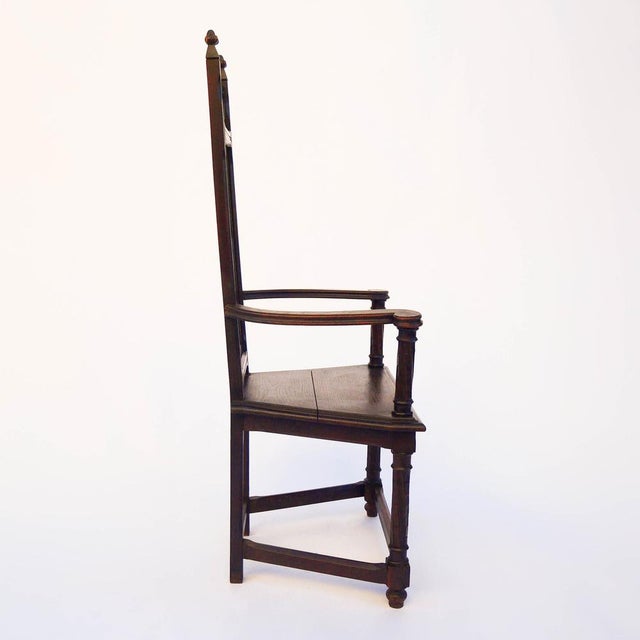 A 19th-century carved oak cabaret chair with refined Gothic and Renaissance-inspired decoration. The back features a...