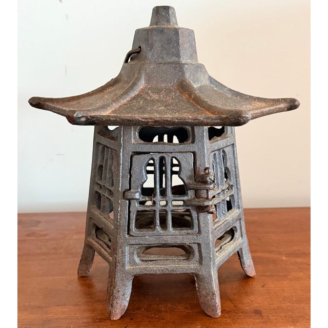 Vintage cast iron Japanese pagoda lantern with slight rust patina and a small door designed to hold a candle. Measure 10"...