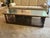 This elegant table is a striking piece that combines natural wood and marble, featuring a mid-century modern aesthetic....