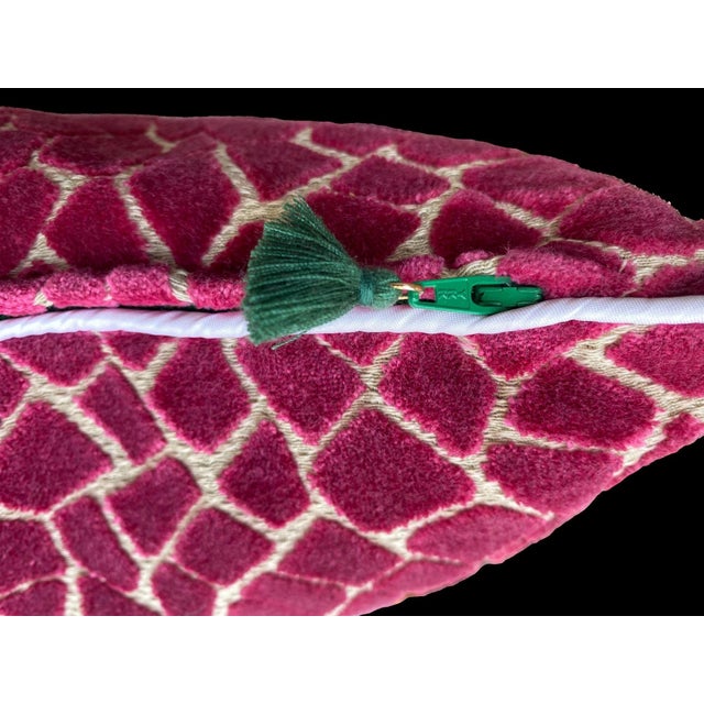 This pillow features a rich magenta velvet with an intricate geometric pattern that resembles a mosaic or giraffe print,...