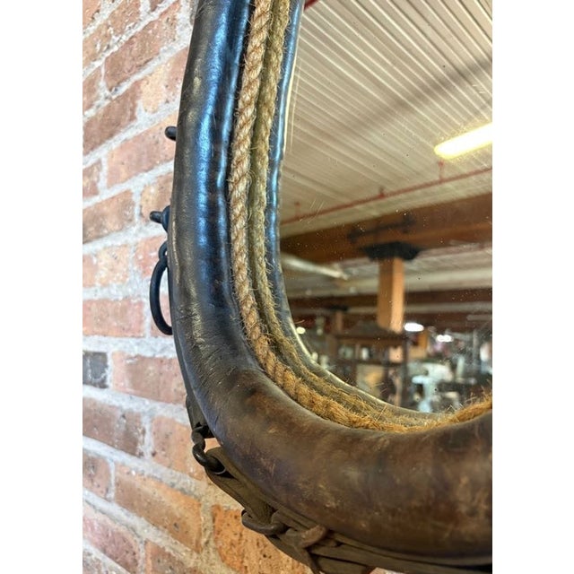Giddy up! This a a very striking wall mirror that has been expertly fashioned from an authentic antique leather draft...