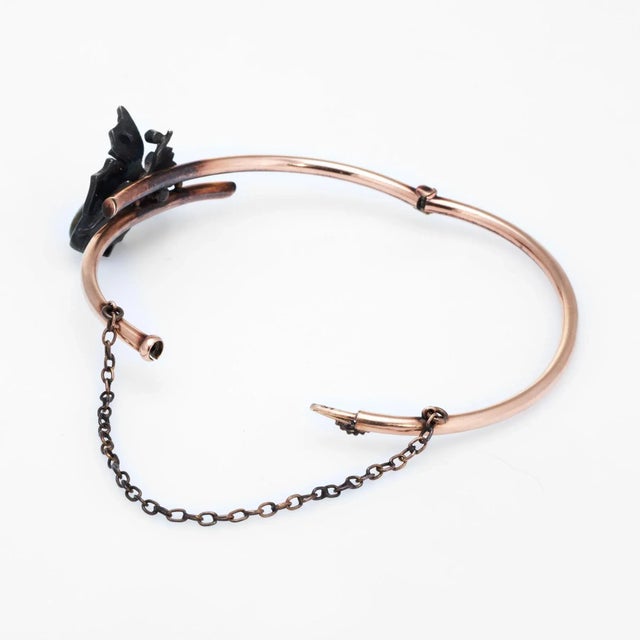 Finely detailed antique Victorian bangle bracelet (circa 1880s to 1900s), crafted in 14k rose gold and silver. The moth is...