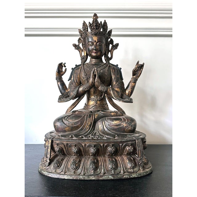 A finely cast bronze statue of Avalokiteshvara in his four-arm form with gilt and polychrome surface. The Bodhisattva of...