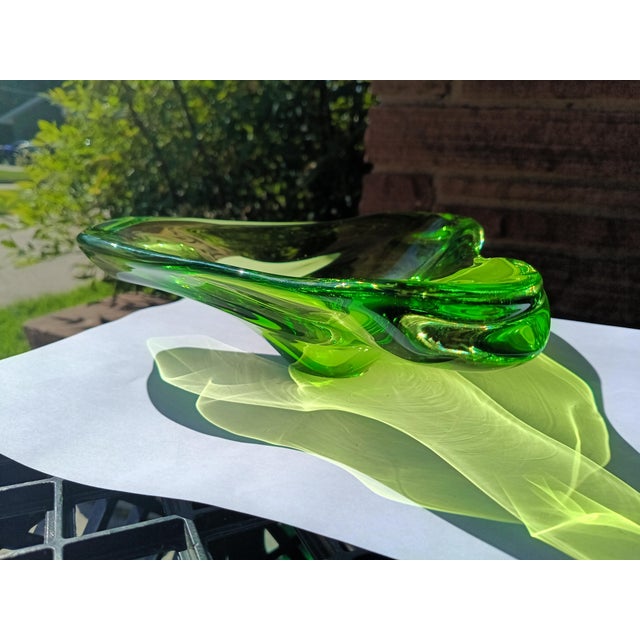 This bold and beautiful mid-century Murano art glass bowl boasts a fluid freeform silhouette and a vivid emerald green...