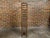 A tall and narrow Midcentury iron wine rack with leather straps. This Midcentury iron wine rack, distinguished by its tall...