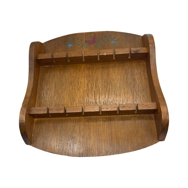 Charming vintage wooden spoon rack featuring a hand-painted folk art bird and floral vine motif at the crest. The warm...