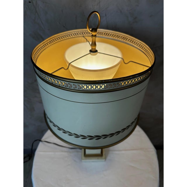 An elegant Empire-style table lamp dating from the 1920s, crafted from cream lacquered metal and enhanced with delicate...