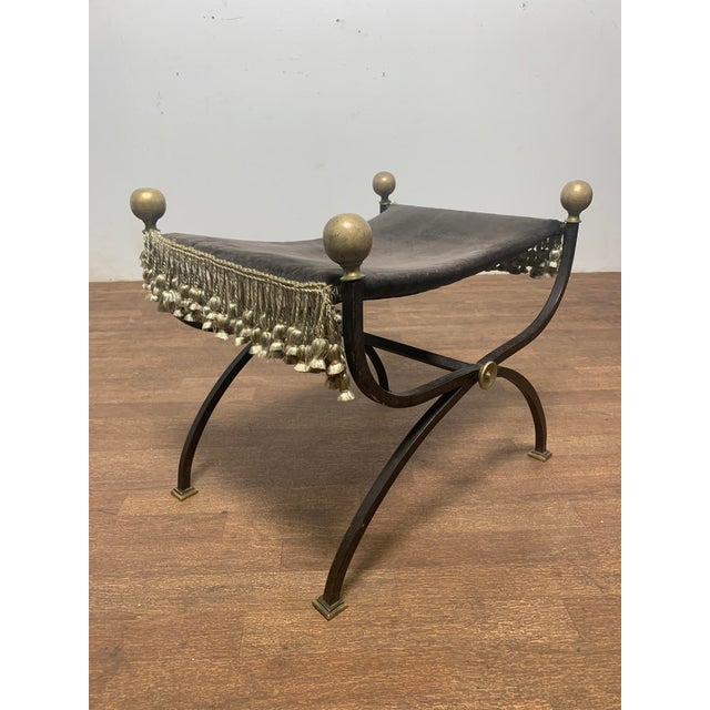 Wrought iron campaign style cerule bench with velvet seat, silk fringe accents and large bronze pommels, circa 1920s.