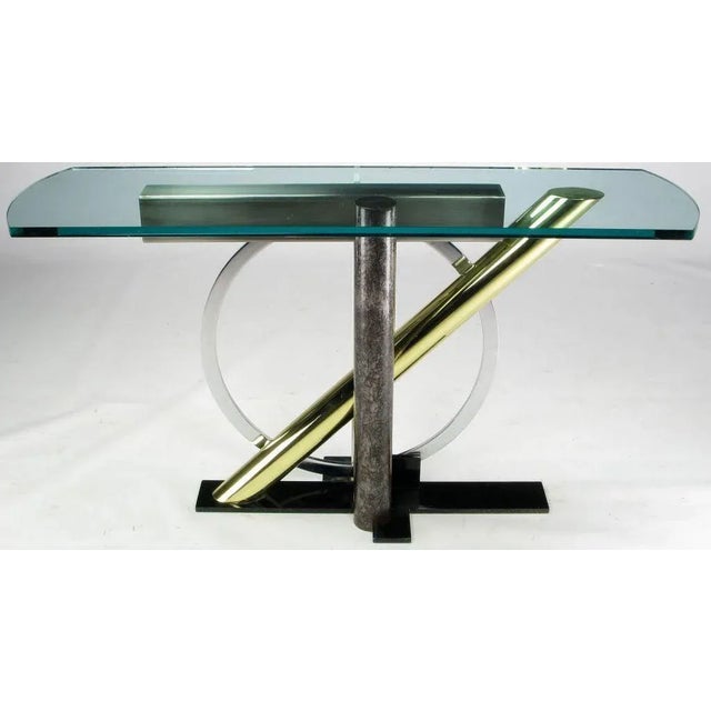 Multi-metal architectural console table with 5/8" glass top by DIA. This "Memphis" inspired piece uses brass, lacquered...