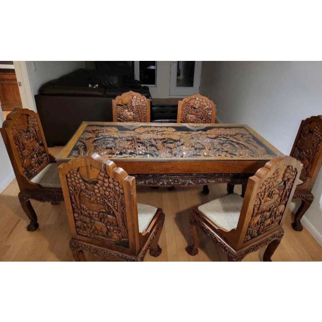 Unique teak and acacia wood carved dining set with 8 different carved chairs. Hand made in Thailand and imported from high...
