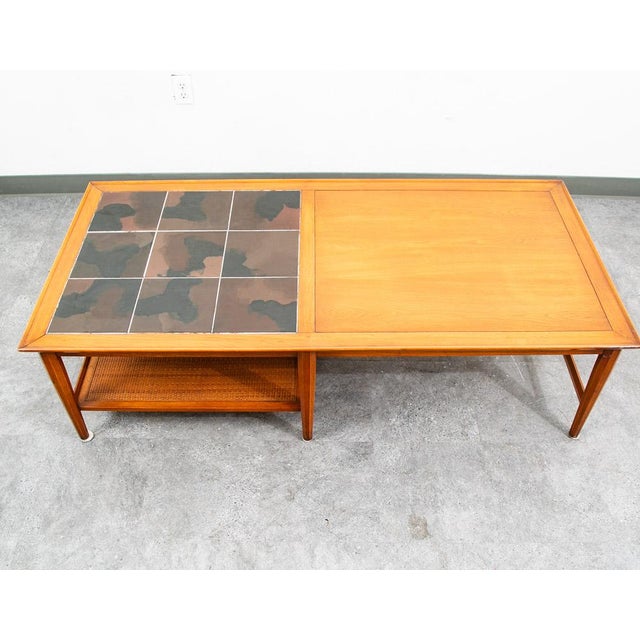 Heritage Tile walnut coffee table with cane shelf beneath. Signed example.