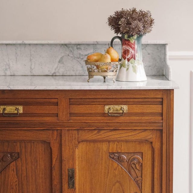 This two-door oak washstand with a marble top and upper section dates from the Art Nouveau period, circa 1900–1910. The...