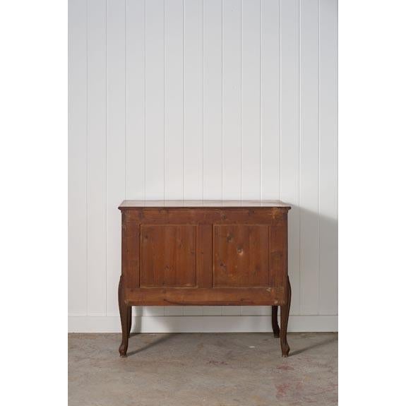 Elegant 1950s Louis XV French-style veneered commode featuring a curved silhouette, rich wood tones, and timeless...