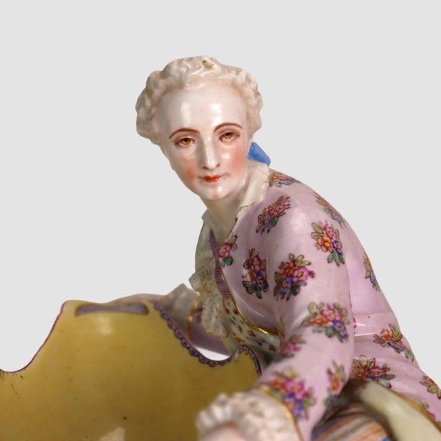 An antique Sevres attr. figural sweetmeat dish, crafted from a combination of bisque and glazed porcelain, dating to...