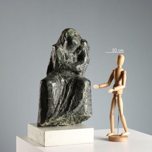 Marble sculpture on a wooden base depicting a woman and child. Engraved signature of the artist. This piece is attributed...