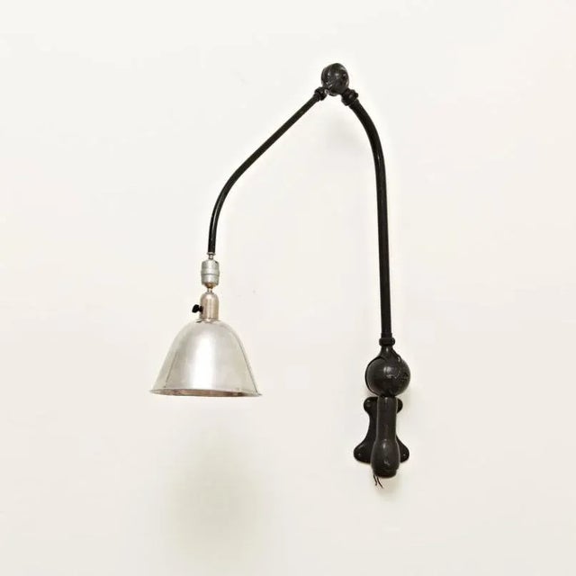 This wall lamp by Johan Petter Johansson features a structure in aluminum and steel and remains in good original...