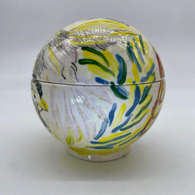 This graceful ceramic globe container was hand-painted by award-winning Folk Artist Virginia Hott Kellogg (1938-2019)....