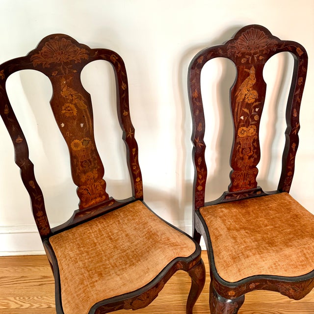 An antique pair of 19th century Dutch marquetry side chairs with mother-of-pearl accents. Each chair back is intricately...