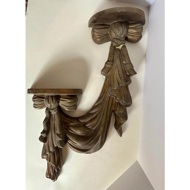 This elegant wall-mounted shelf features a classic design with a rich bronze-tone finish. The shelf showcases intricate...