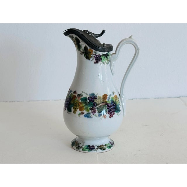Circa 1880, English Victorian Floral Decorated Ironstone Syrup Jug. Beautifully hand decorated with three bands of...