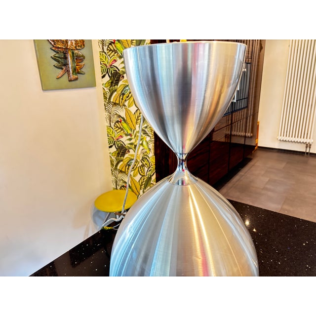 Large hourglass-shaped pendant light in brushed aluminum with dual lighting and an interior pull-chain switch. No dents,...