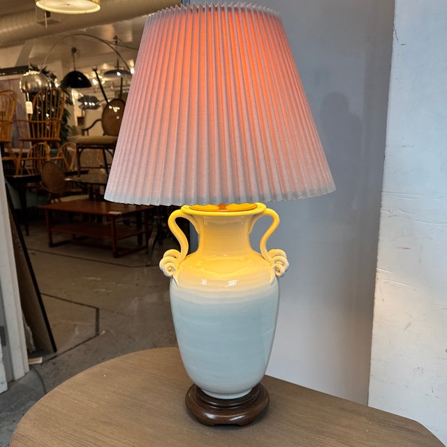 Design Plus Gallery presents a Classic Amphora Ceramic Table Lamp. This table lamp has a glossy cream ceramic urn body...