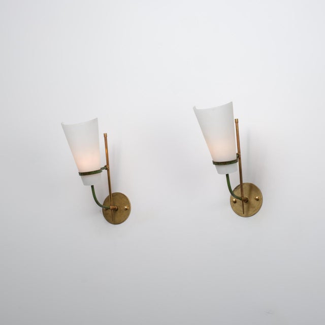 Pair of Italian wall sconces from the 1950s, crafted in brass with green lacquered metal elements and opaline glass...