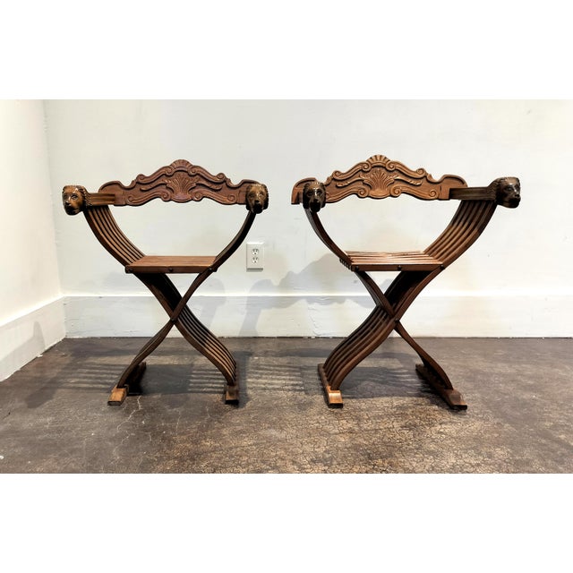 Charming pair of folding wood chairs made in Italy circa 1950. Savonarola style chairs with whimsical carved lion heads...