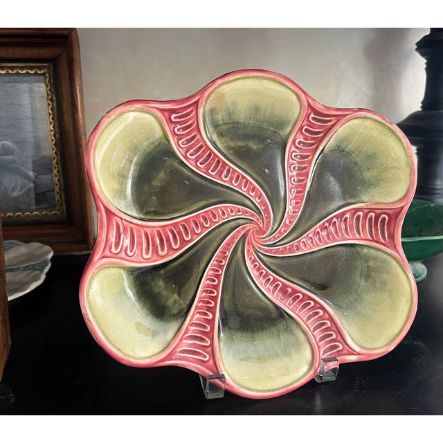 French majolica platter with a pink swirl pattern over a black and tan background, made around the 1920's