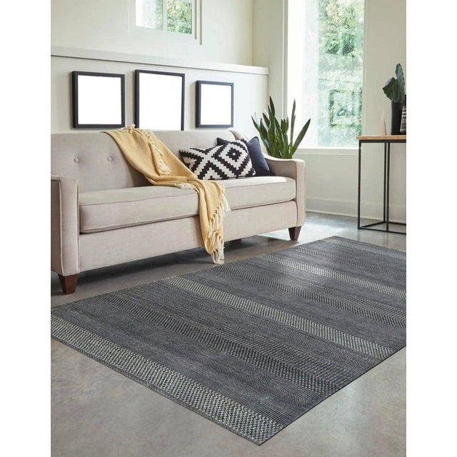 This gray hand knotted pile rug is constructed from a blend of wool and viscose. Originating from India, this piece aligns...