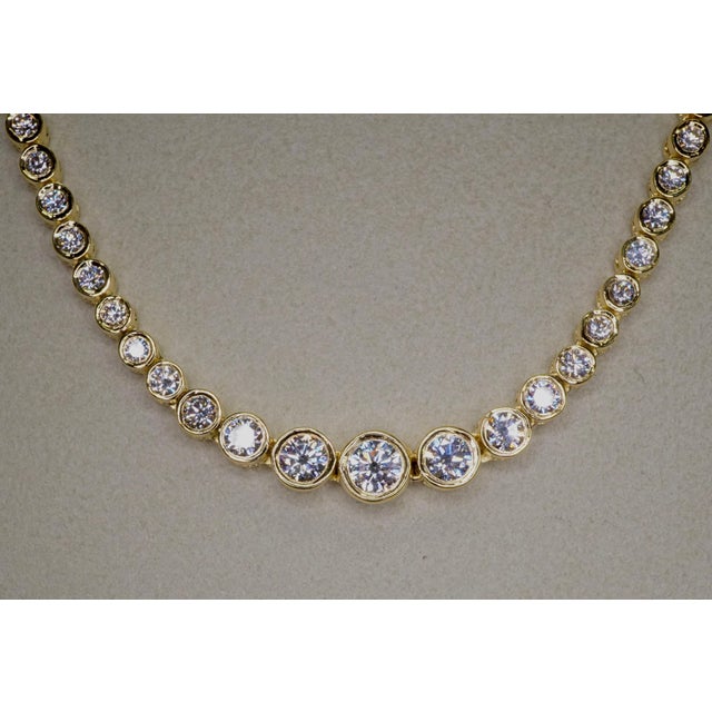 Diamond Tennis Necklace in 18K Yellow Gold. Bezel set natural brilliant round diamonds are F-G VS2-SI1. Total carat weight...