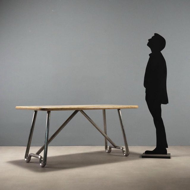 1970s table with a distinctive design combining a chrome-plated aluminum tubular base with a marble top. The aluminum...