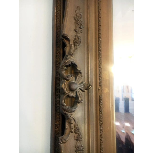 This large, circa 1900, mirror features ornate corners with an acanthus motif. The finish is a very muted gold tone....