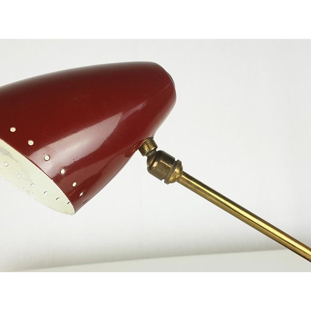 Small adjustable table lamp made from brass and painted metal. It remains in good vintage condition: slight deformation of...